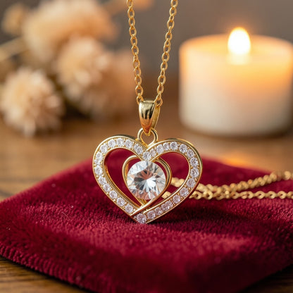 Detalle del colgante de doble corazón dorado con piedra blanca